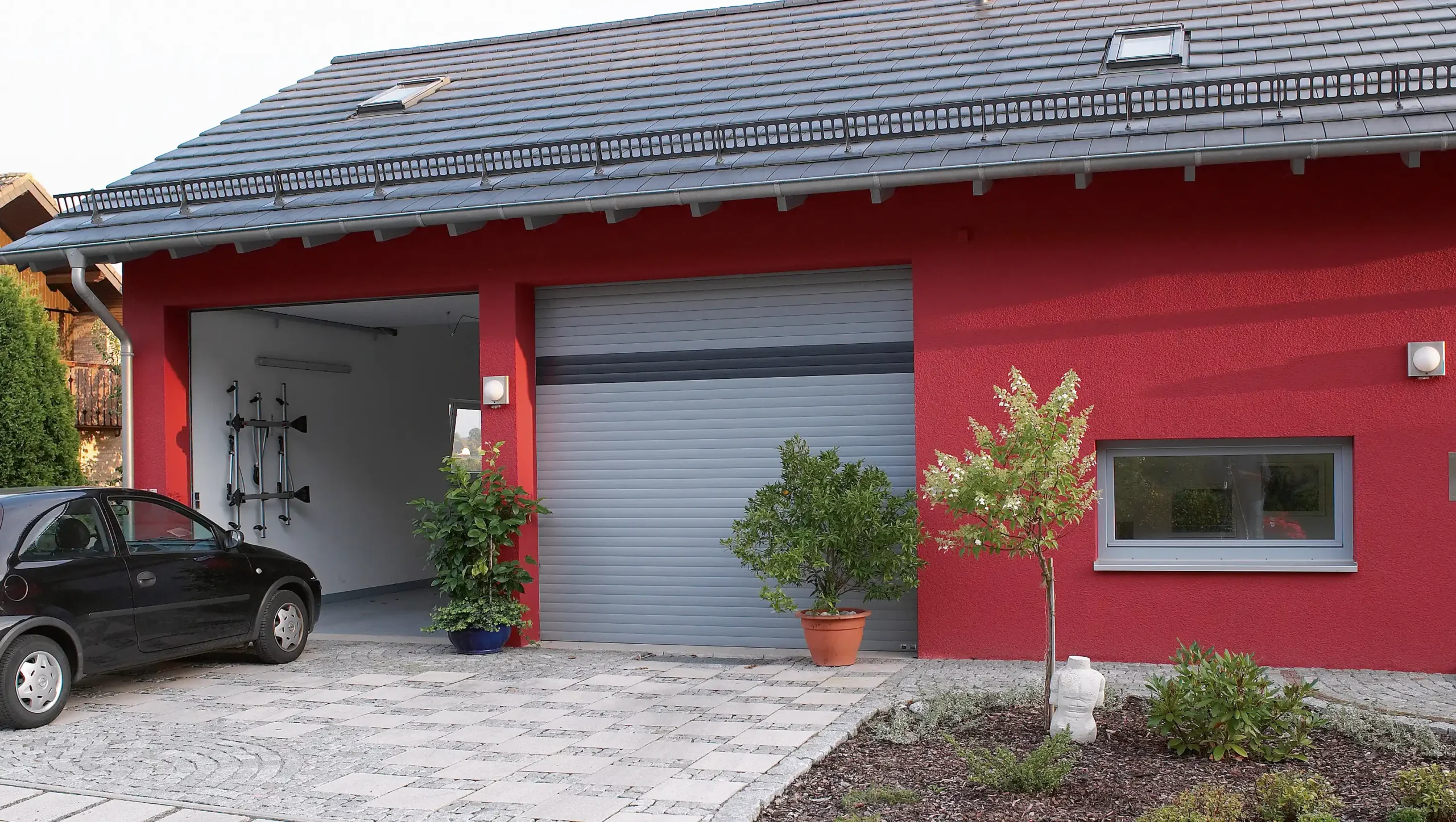 Deckenlauftore von Roma an integrierter Garage in rotem Haus